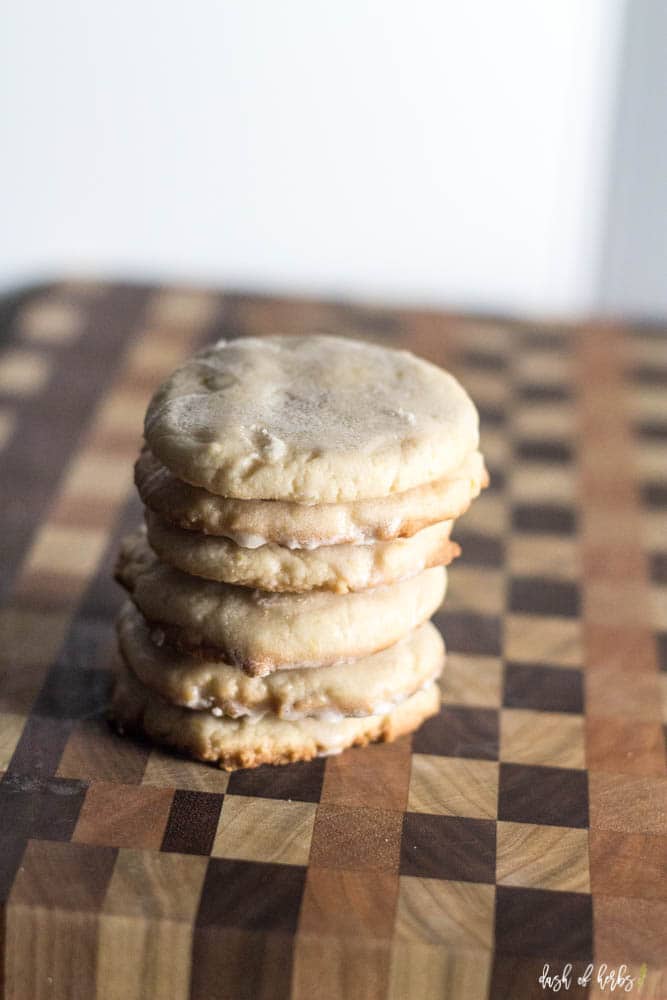 A close up image of the Vegan Lemon Cookies recipe on a cutting board.  The cookies are stacked six cookies high.